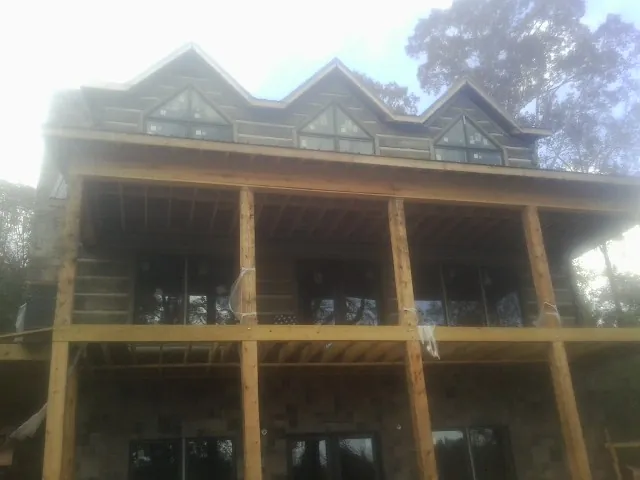 Dormers and porch framing on a large log home under construction — Roof Coating work by our crew in Fort Montgomery