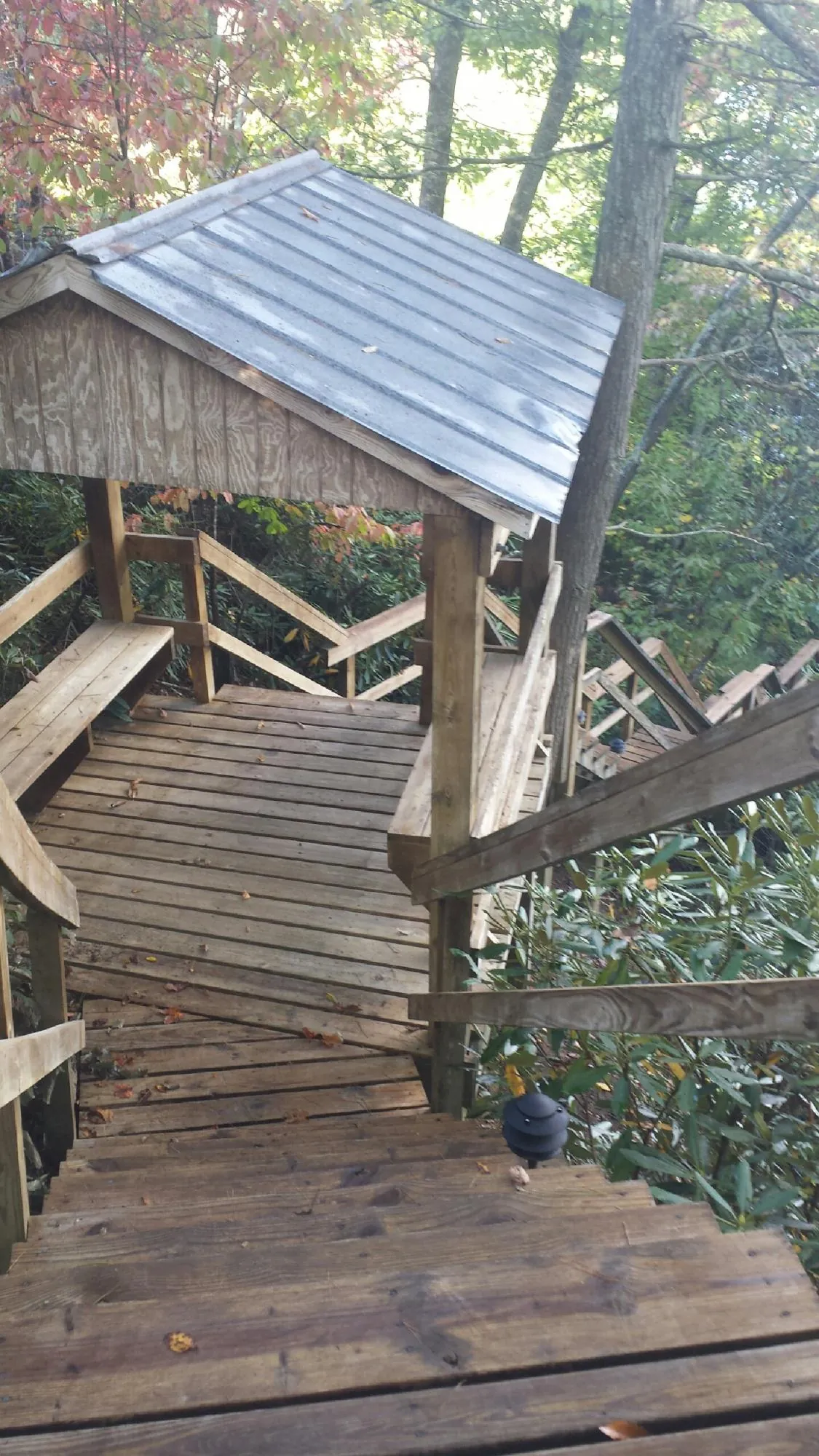 Metal roofed shelter over wooden steps on a wooded walkway — Skylight Repair & Installation work by our crew in Fort Montgomery